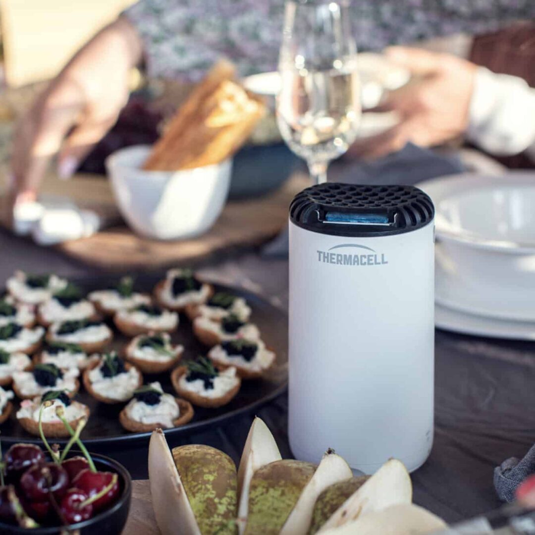 Utomhusmiddag med Thermacell myggmedel och aptitretare på bordet.