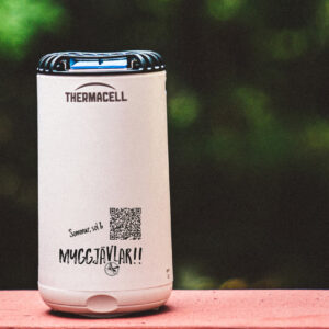 Myggavstötande Thermacell-enhet utomhus på en bänk.