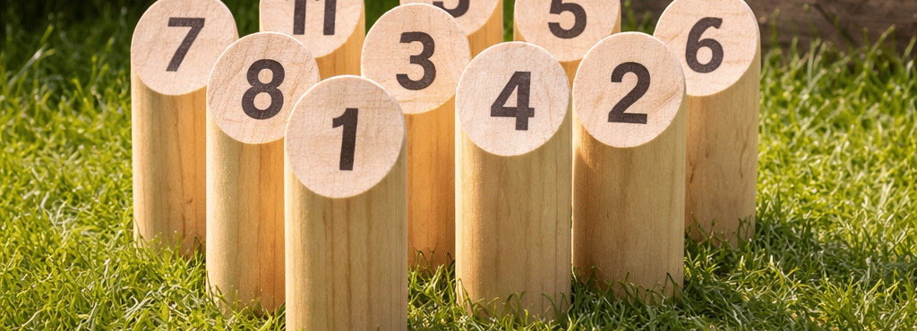 Träpjäser med nummer för finska spelet Mölkky på gräsmattan.